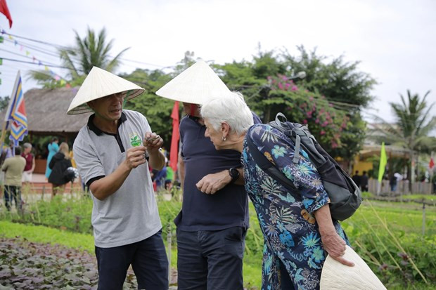 Los aldeanos de Tra Que muestran a los turistas las verduras cultivadas en la localidad. (Foto: sggp.org.vn)