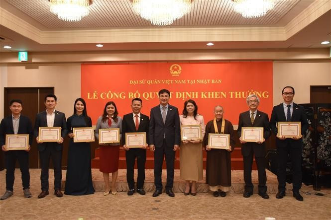 El embajador vietnamita en Japón, Pham Quang Hieu (quinto desde la derecha), entrega certificados de mérito a los colectivos e individuos con logros destacados en asuntos de la comunidad vietnamita el 9 de junio. (Foto: VNA)
