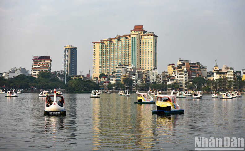 Actividades interesantes en el lago Truc Bach bajo el sol dorado de la tarde el primer día del Año Nuevo.
