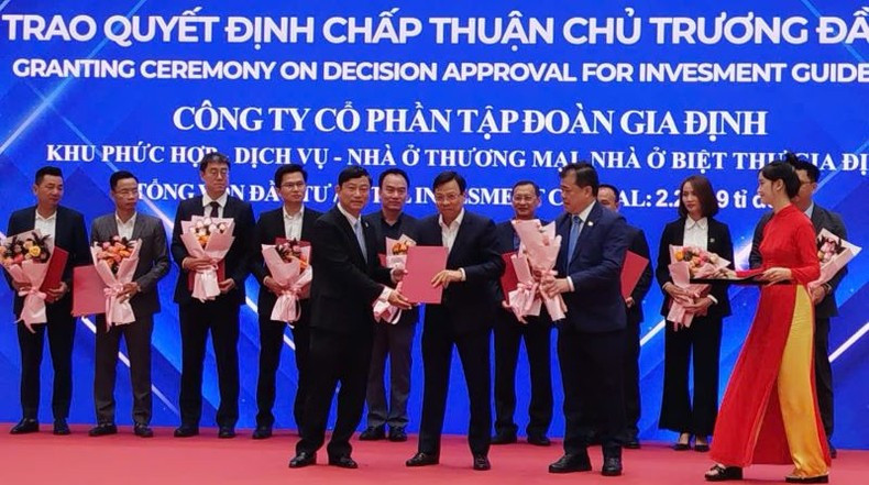El presidente del Comité Popular de la provincia de Binh Duong, Vo Van Minh (primera fila, primera posición a la izquierda), entrega la Decisión que aprueba la política de inversión en el sector inmobiliario a las empresas.