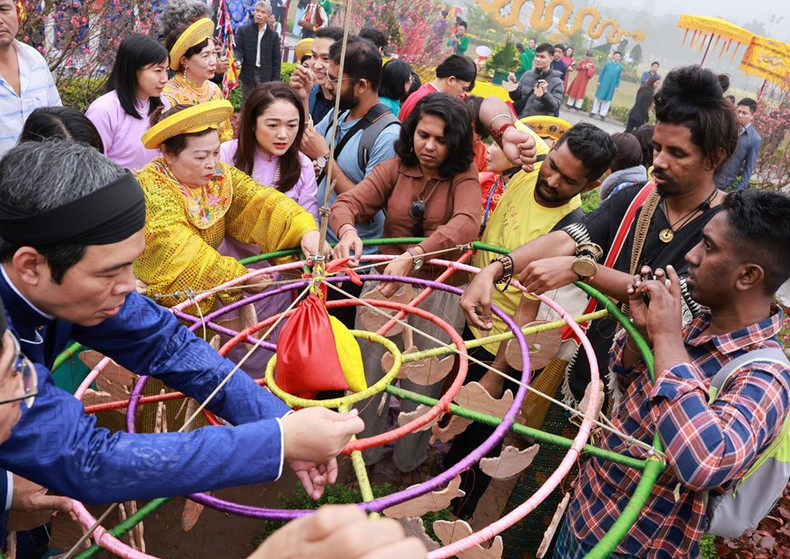 Visitantes extranjeros participan en el levantamiento de “Cay Neu” en ocasión del Tet.