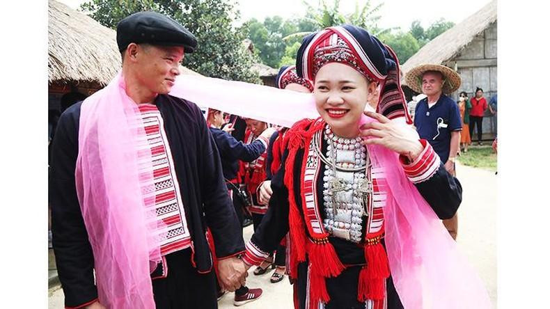 La joven pareja se ata el pañuelo rojo, que representa un lazo para crear un matrimonio duradero. La joven pareja se ata el pañuelo rojo, que representa un lazo para crear un matrimonio duradero.