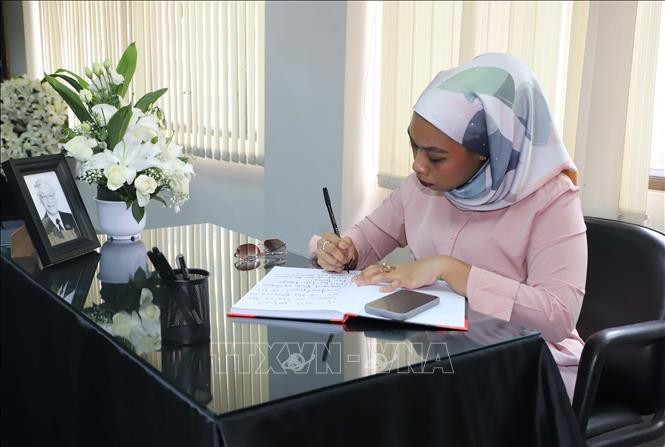 Nur Amirah Mohamad, representante del Consulado General de Malasia en Hong Kong y Macao (China), escribe en el libro de condolencias.