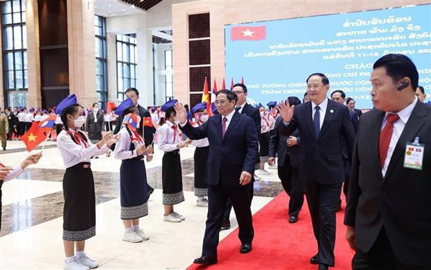 El primer ministro de Vietnam, Pham Minh Chinh, y su homólogo de Laos, Sonexay Siphandone, saludan a los niños laosianos (Fotografía: VNA) El primer ministro de Vietnam, Pham Minh Chinh, y su homólogo de Laos, Sonexay Siphandone, saludan a los niños laosianos (Fotografía: VNA)