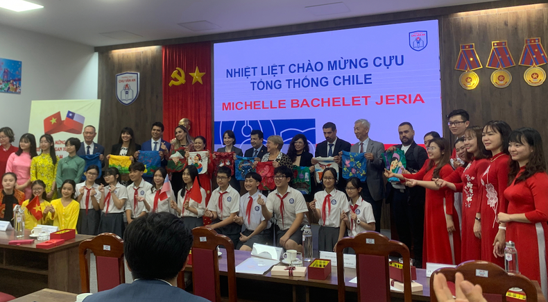 Maestros y estudiantes de la escuela se toman fotos con los visitantes.