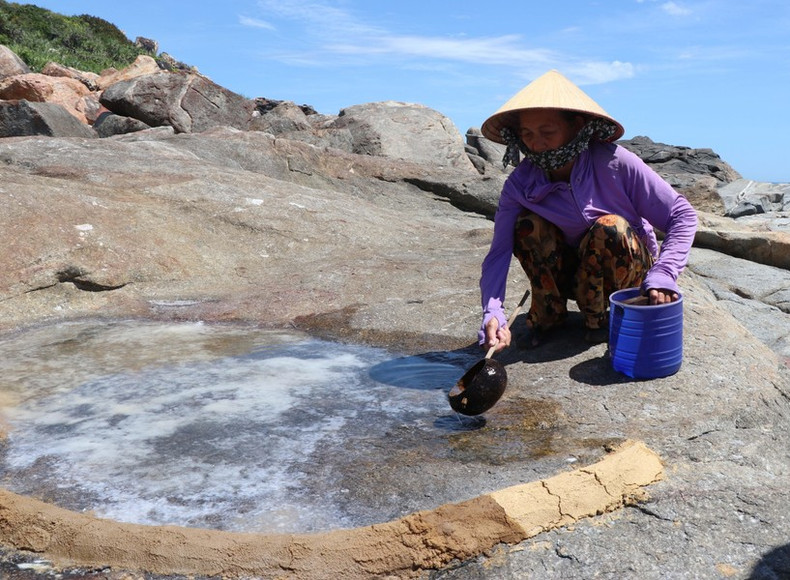 Los pobladores del barrio Co vierten agua marina en las rocas para aumentar el espesor de la sal.