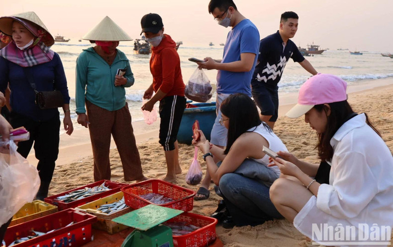 Muchos turistas observan la atmósfera del comercio marítimo en Nhan Trach y no se olvidan de tomar fotos de las actividades de los residentes locales.