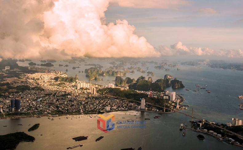 La ciudad de Ha Long se hunde en nubes doradas bajo el sol poniente.