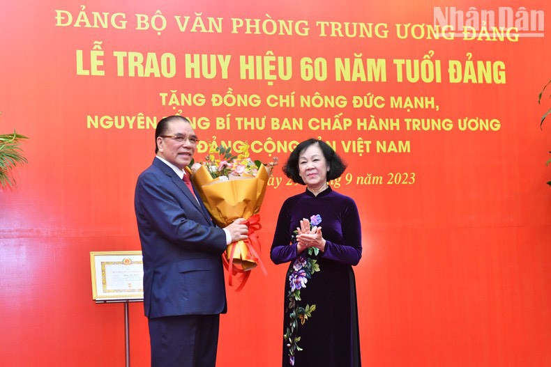 La jefa de su Comisión de Organización del PCV, Truong Thi Mai, entrega flores a Nong Duc Manh. La jefa de su Comisión de Organización del PCV, Truong Thi Mai, entrega flores a Nong Duc Manh.