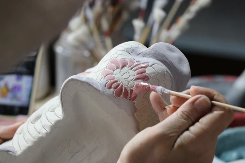 Artistas aplican esmalte y dibujan patrones en productos cerámicos de Bien Hoa en el horno de alfarería de Phong Son. Artistas aplican esmalte y dibujan patrones en productos cerámicos de Bien Hoa en el horno de alfarería de Phong Son.