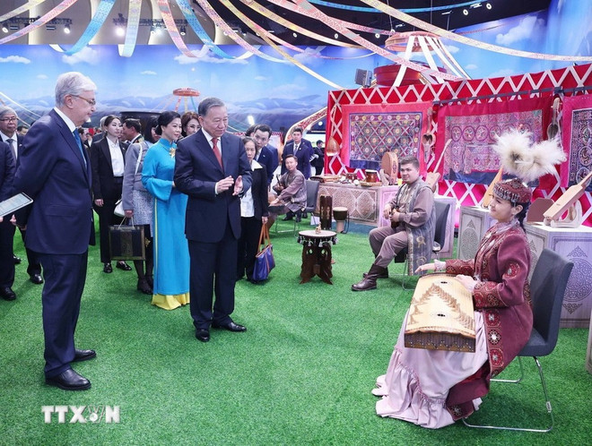 El secretario general To Lam y su esposa, junto con el presidente kazajo, Kassym-Jomart Tokayev, visitan la aldea cultural étnica en Astaná. (Foto: VNA)