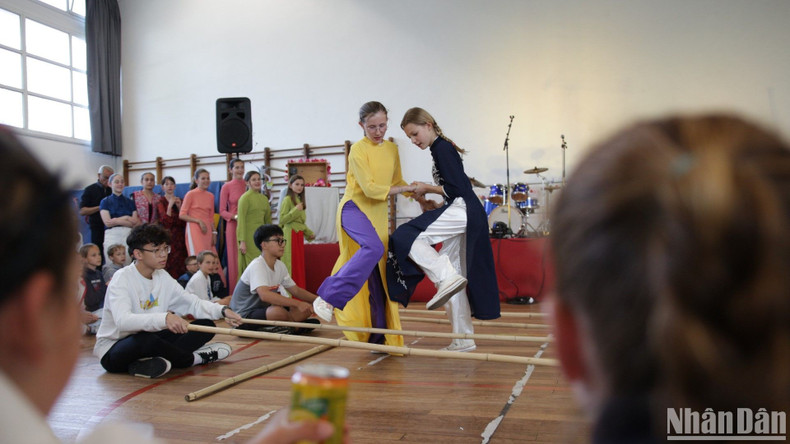 Los amigos franceses e internacionales dispfrutan de los juegos folclóricos vietnamitas. (Foto: Nhan Dan)