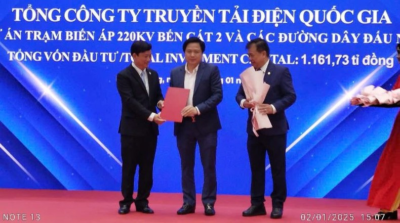 El presidente del Comité Popular de Binh Duong, Vo Van Minh, entrega la licencia de inversión a un representante de la Corporación Nacional de Transmisión Energética.
