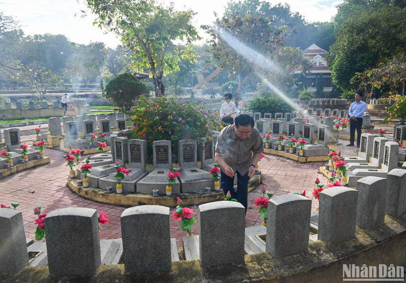 Dinh Hue quema incienso ante las tumbas de los mártires.
