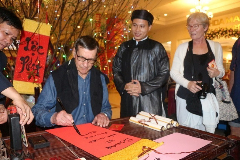 Turistas extranjeros experimentan costumbres tradicionales vietnamitas al comienzo del nuevo año lunar. Turistas extranjeros experimentan costumbres tradicionales vietnamitas al comienzo del nuevo año lunar.