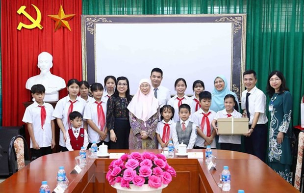 Las cónyuges de los premieres de Vietnam, Le Thi Bich Tran, y de Malasia, Dato’ Seri Dr. Wan Azizah binti Dr. Wan Ismail, entregan regalos para los niños en la Aldea Infantil SOS en Hanói (Foto: VNA)