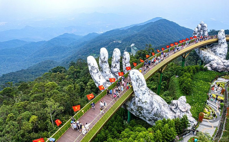 Los turistas visitan el Puente Dorado en Sun World Ba Na Hills. Los turistas visitan el Puente Dorado en Sun World Ba Na Hills.