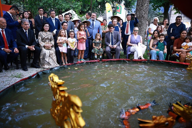 El premier vietnamita, Pham Minh Chinh, su esposa y los delegados disfrutan de títeres de agua.