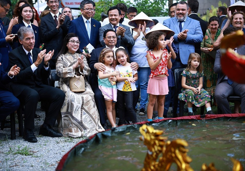 El premier vietnamita, Pham Minh Chinh, su esposa y los delegados disfrutan de títeres de agua.
