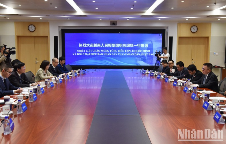 El presidente-editor de Nhan Dan, Le Quoc Minh, sostiene conversaciones con el dirigente del Diario del Pueblo, Tuo Zhen. (Fotografía: Nhan Dan)