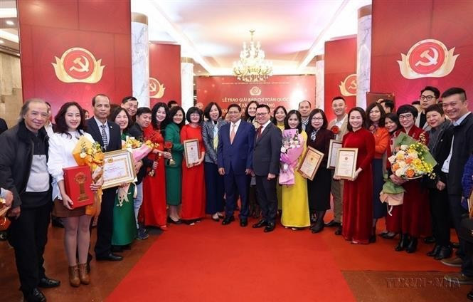 El primer ministro Pham Minh Chinh se toma una foto con los periodistas de la Agencia Vietnamita de Noticias que ganan el octavo Premio Nacional de Prensa sobre Construcción del Partido, Bua Liem Vang (Hoz y Martillo de Oro). (Fotografía: VNA)