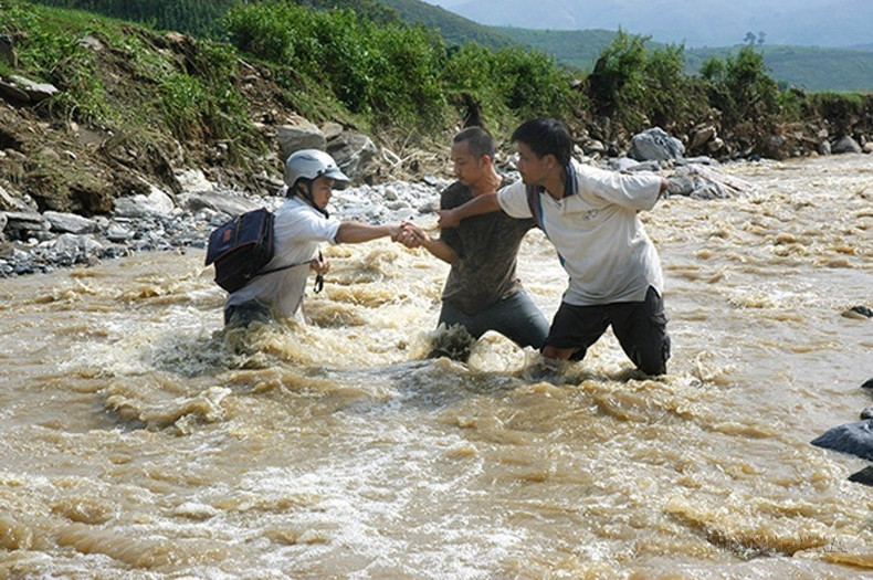 El periodista de la Agencia Vietnamita de Noticias Xuan Truong y sus colegas trabajan en medio de una inundación en la provincia de Lao Cai, en 2008. El periodista de la Agencia Vietnamita de Noticias Xuan Truong y sus colegas trabajan en medio de una inundación en la provincia de Lao Cai, en 2008.