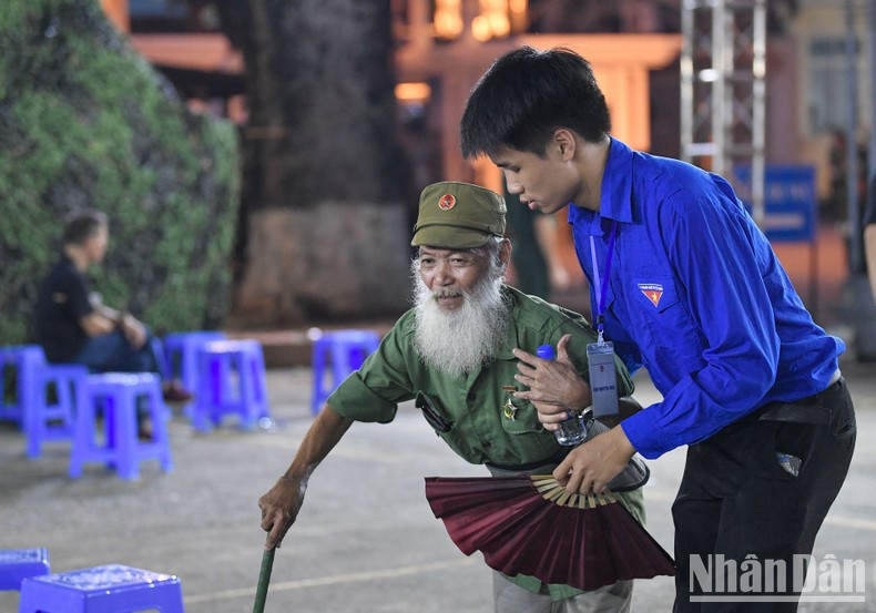 Los mayores con dificultad para caminar son ayudados por voluntarios en el sitio.
