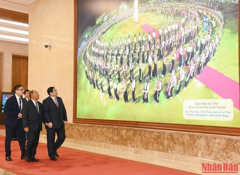 El dirigente anfitrión enseña a los visitantes imágenes sobre el país y la gente de Vietnam.