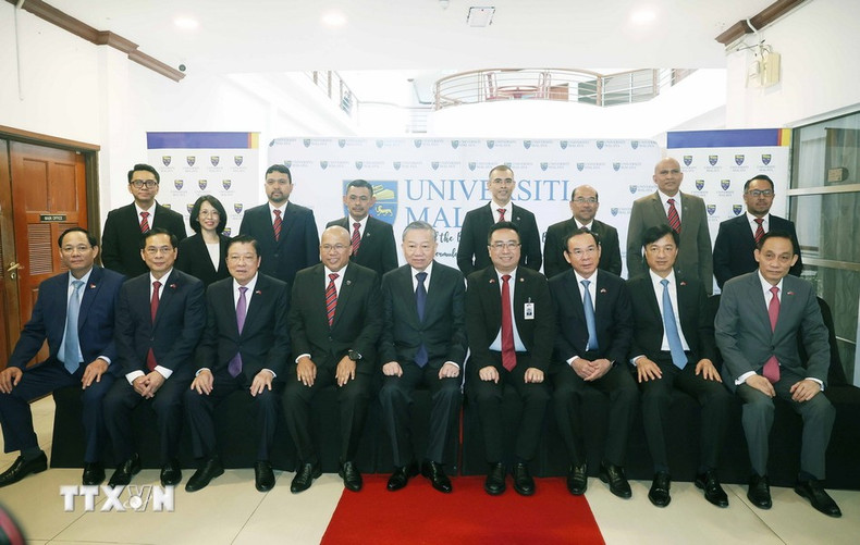 El máximo dirigente político de Vietnam posa junto a otros participantes.