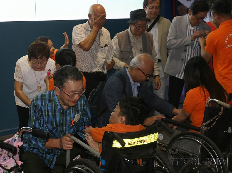 Niños de la Aldea de Paz, víctimas del Agente Naranja/dioxina, entregan suvenires a los delegados japoneses que asisten a una exposición fotográfica sobre las víctimas de la guerra en Japón y Vietnam. Niños de la Aldea de Paz, víctimas del Agente Naranja/dioxina, entregan suvenires a los delegados japoneses que asisten a una exposición fotográfica sobre las víctimas de la guerra en Japón y Vietnam.