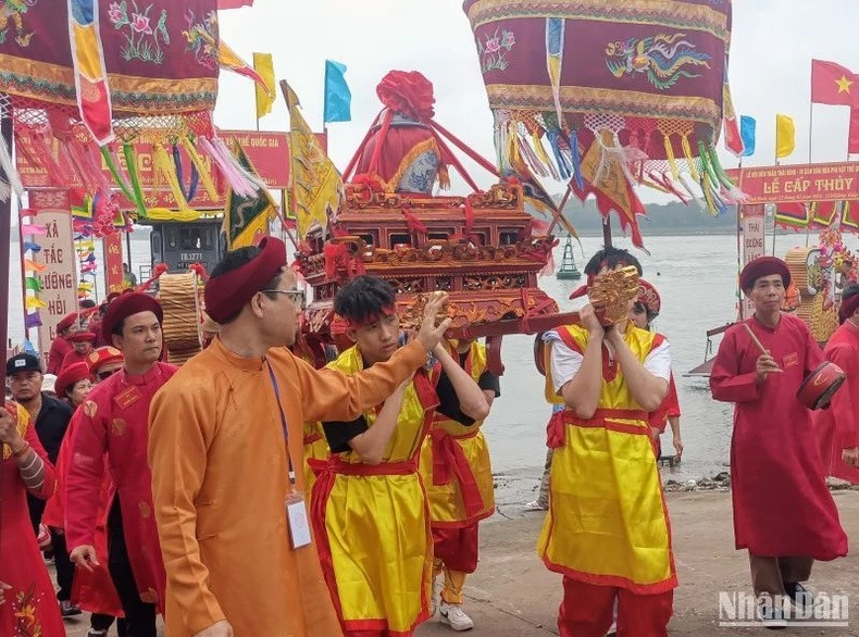Jóvenes en la comuna de Tien Duc llevan al Templo Tran la litera en que se coloca el jarrón de agua. Jóvenes en la comuna de Tien Duc llevan al Templo Tran la litera en que se coloca el jarrón de agua.