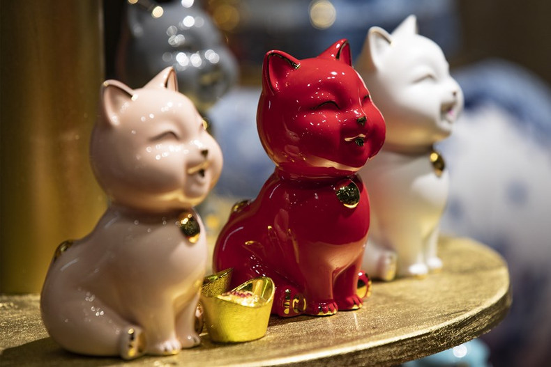 Estatua de gato de mil felicidades con decoración dorada.