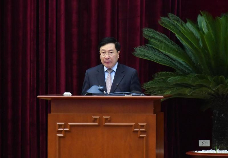 El miembro del Buró Político y vice primer ministro permanente, Pham Binh Minh, presenta un informe.