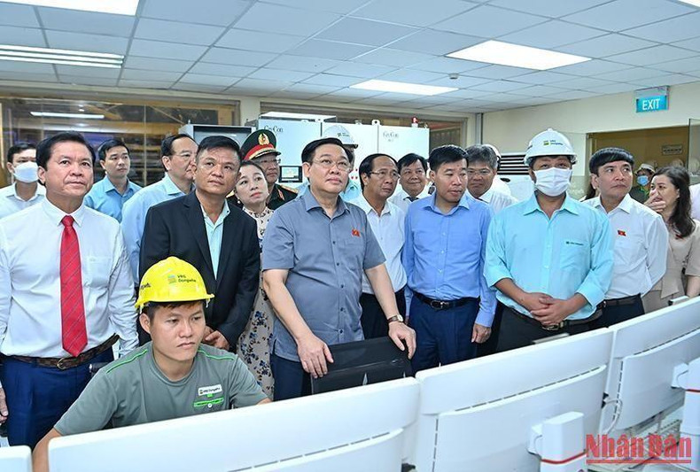 Los visitantes observan la línea de producción en la fábrica.