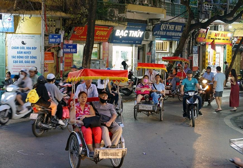 Turistas extranjeros visitan la calle de Dinh Liet en triciclos.