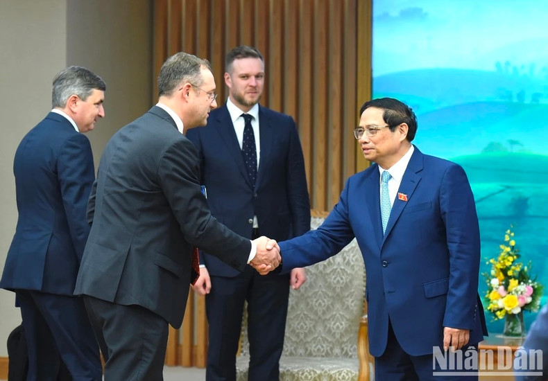 El jefe de Gobierno saluda a los delegados lituanos.
