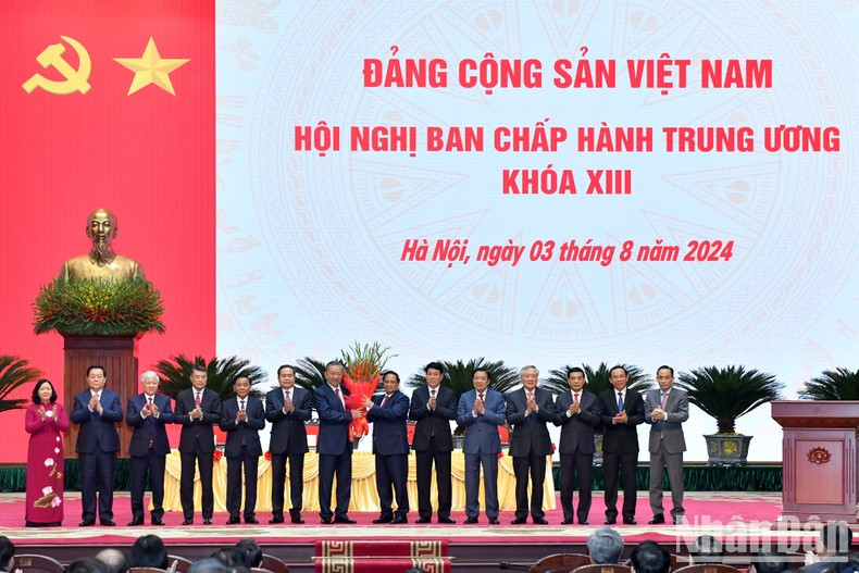 El miembro del Politburó y primer ministro Pham Minh Chinh entrega flores al camarada To Lam en nombre de los dirigentes del Partido y del Estado para felicitarle por su elección como secretario general del PCV del XIII mandato.