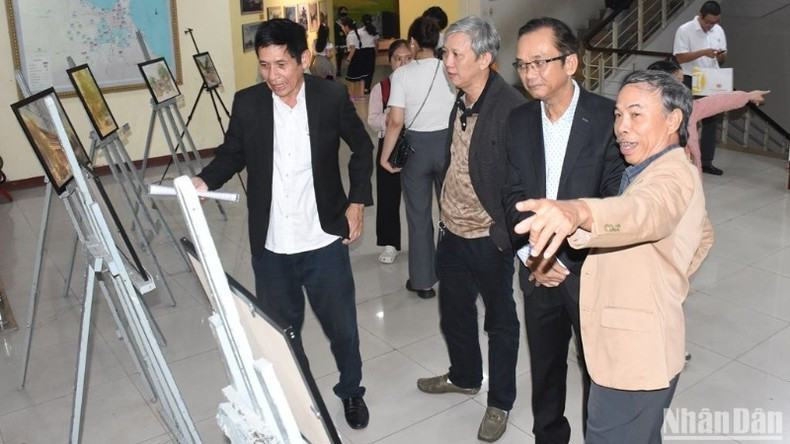 Los delegados echan un vistazo a fotos de las casas comunitarias de las aldeas de Da Nang.