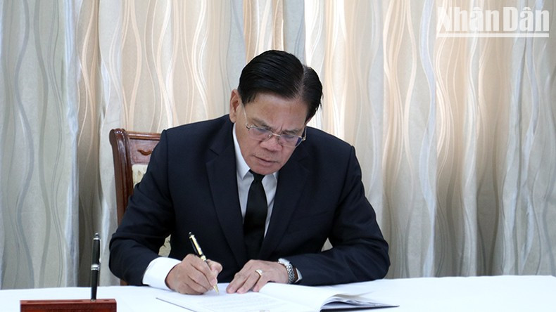 El embajador de Laos en Camboya, Buakeo Phumvongsay, firma el libro de condolencias.