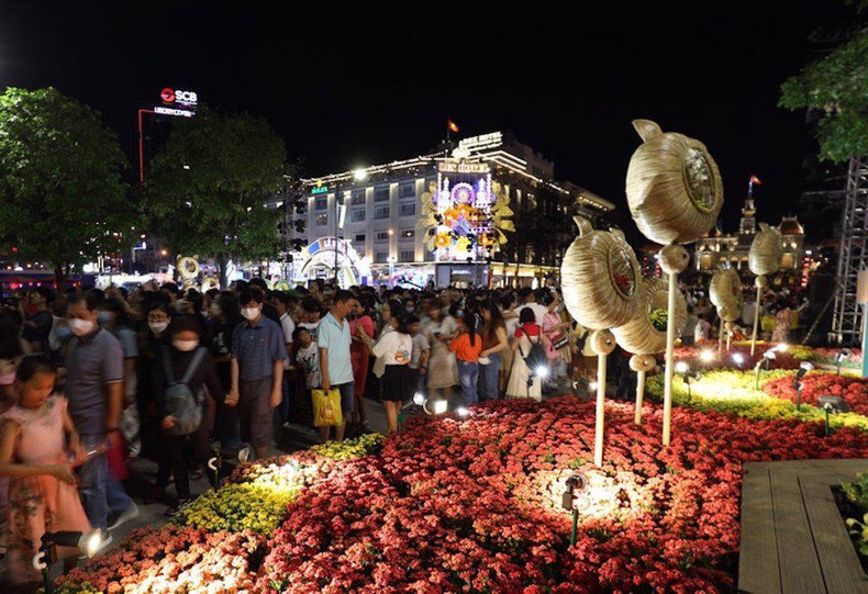 Miles de personas afluyen a la calle peatonal de Nguyen Hue para tomar fotos junto con arreglos florales allí. (Fotografía: kinhtedothi.vn) Miles de personas afluyen a la calle peatonal de Nguyen Hue para tomar fotos junto con arreglos florales allí. (Fotografía: kinhtedothi.vn)