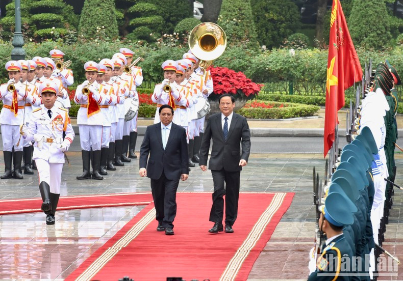El premier vietnamita y su homólogo laosiano pasan revista a la guardia de honor. El premier vietnamita y su homólogo laosiano pasan revista a la guardia de honor.