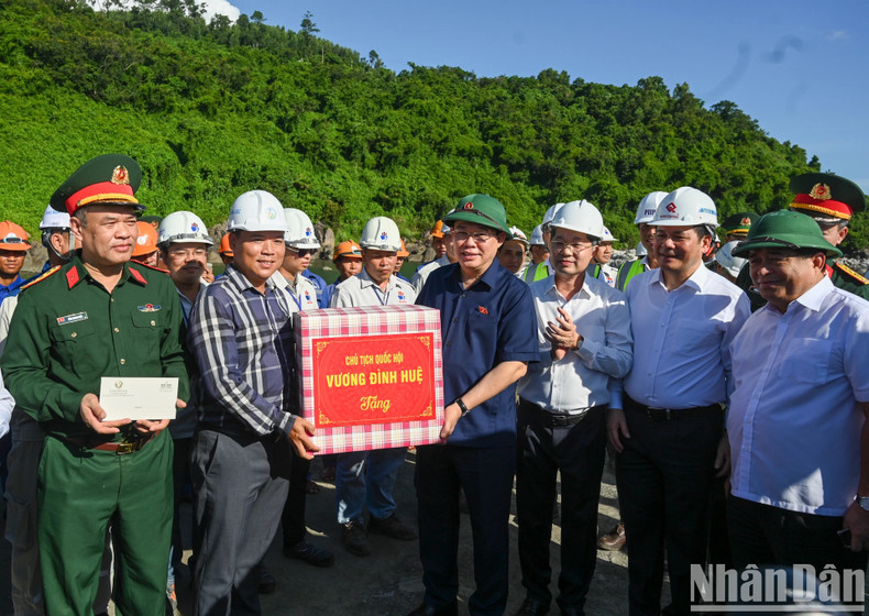 El presidente de la Asamblea Nacional entrega un regalo a los encargados del proyecto.