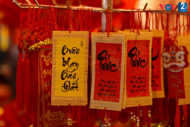 La gente disfruta de la atmósfera del Tet y se toma fotos junto a tiendas engalanadas con coloridas decoraciones. La gente disfruta de la atmósfera del Tet y se toma fotos junto a tiendas engalanadas con coloridas decoraciones.