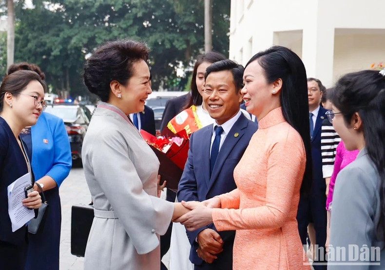 Las primeras damas de Vietnam y China se saludan en el campus de la Universidad Nacional de Hanói.
