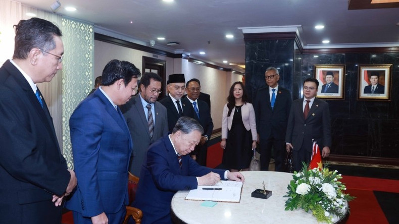 El máximo dirigente político de Vietnam firma el libro de visita.