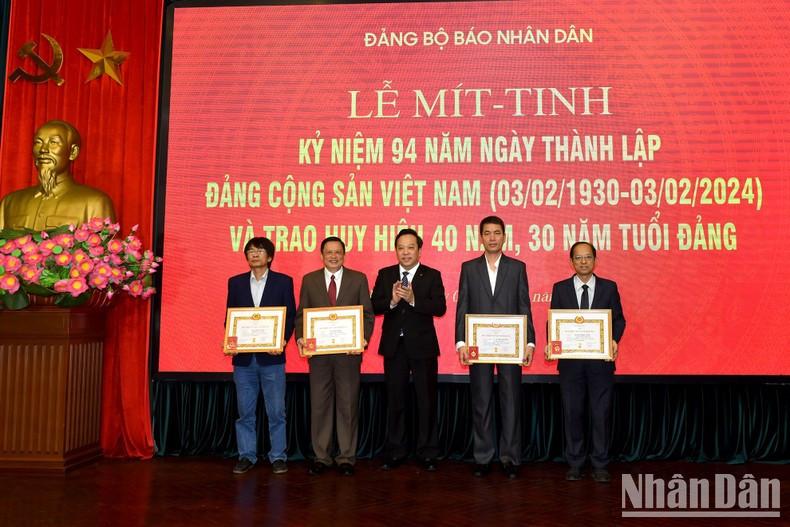 El compañero Do Viet Ha, vicesecretario del Comité partidista del Bloque de Órganos Centrales, entrega insignias a cuatro empleados de Nhan Dan que han cumplido 30 y 40 años de militancia. El compañero Do Viet Ha, vicesecretario del Comité partidista del Bloque de Órganos Centrales, entrega insignias a cuatro empleados de Nhan Dan que han cumplido 30 y 40 años de militancia.