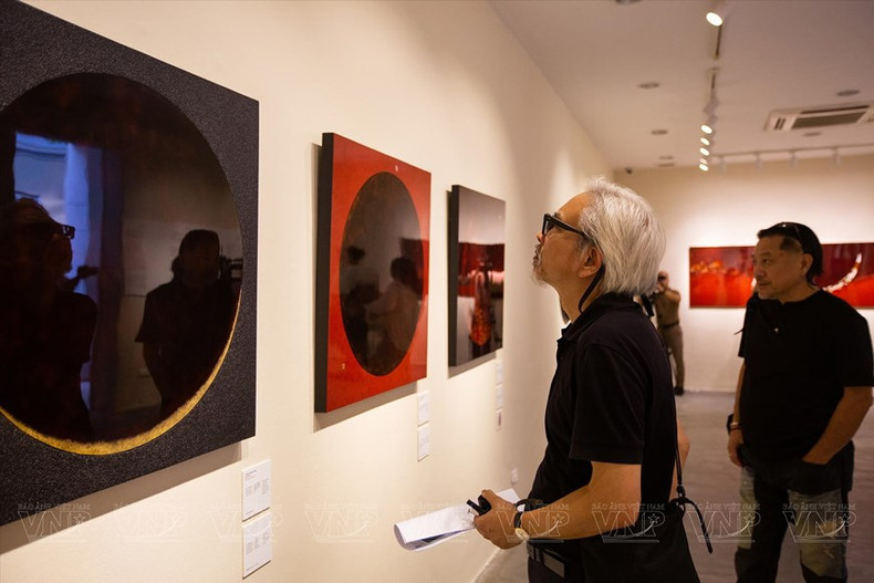 El público aprecia las obras en la exhibición. (Fotografía: VNA)