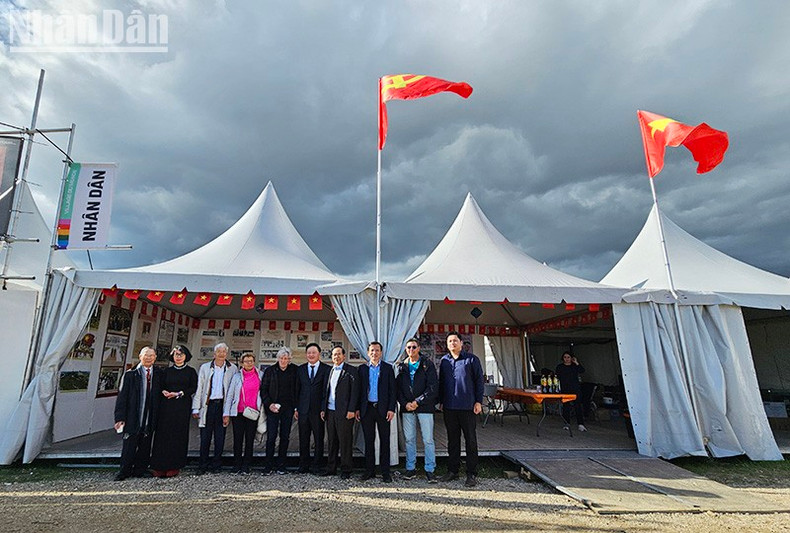 Los delegados posan en el pabellón de Vietnam en la fiesta. (Fotografía: Nhan Dan)
