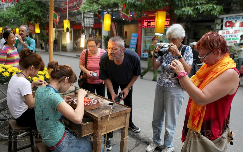 Los turistas exploran el oficio de platería en la calle de Hang Bac. Los turistas exploran el oficio de platería en la calle de Hang Bac.