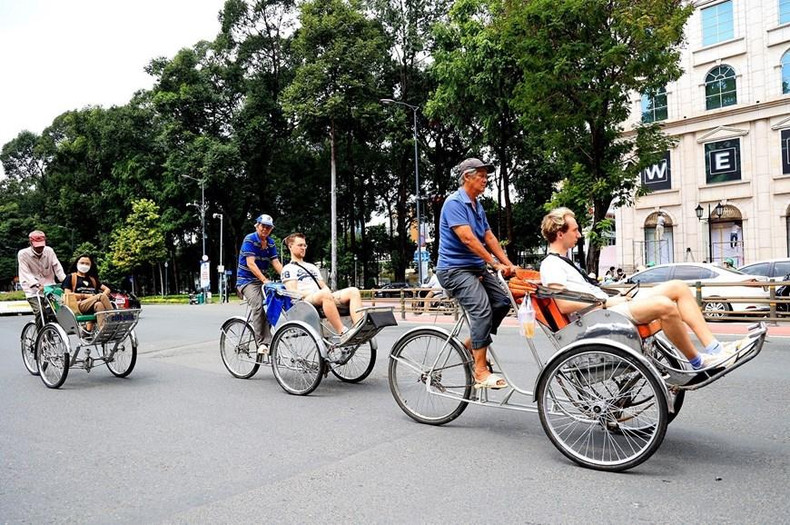Turistas extranjeros recorren Hanói en triciclos.